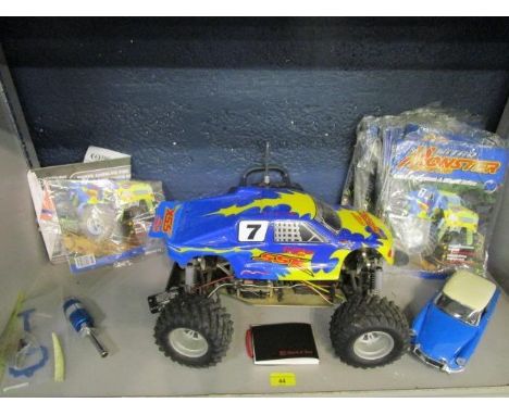 A Nitro Monster Trucks 4WD radio controlled vehicle, with a group of magazines and accessories, along with a Solido model of 