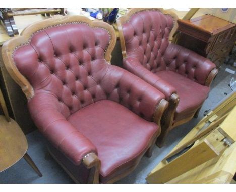 A pair of modern walnut framed, red leather, button back armchairs 
