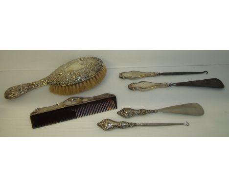 Silver backed hairbrush, a silver handled shoe horn and button pull and another in matching design and a silver hallmarked co