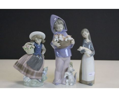Three Lladro ceramic Figurines to include a Girl with a Basket of Kittens and another holding a Pig, tallest approx 21.5cm