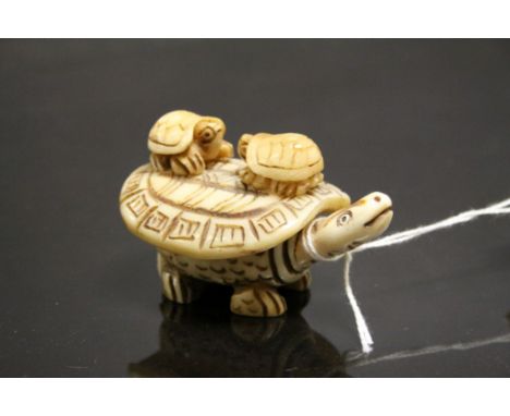 Bone netsuke figure of a Tortoise with two babies to shell
