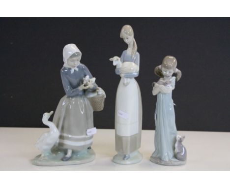 Three Lladro ceramic Figurines, one with Cats, another with Ducks and the third with a Lamb, tallest approx 27cm