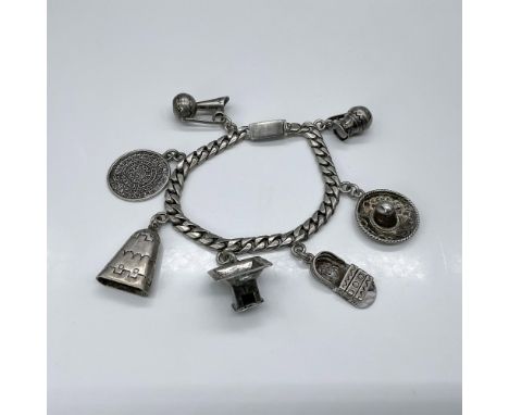 Vintage Castelan designers charm bracelet with charms such as an Aztec disc, a sombrero, a sandal, stove, bell, and two pitch