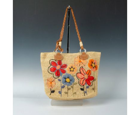 Woven straw bag decorated with colorful flowers and leather handles. Magnetic closure opens to canvas-lined interior with poc