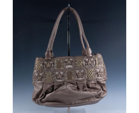 Taupe and bronze leather tote designed with geometric circles. Two separate interior sections. Magnetic closure opens to fabr