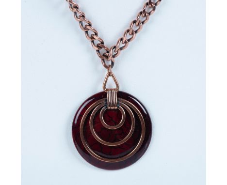 This striking necklace is a disc shape of cognac color enamel over copper. There are thin swirls of copper applied on the fro