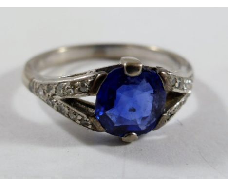 WHITE METAL, THOUGHT TO BE WHITE GOLD, RING SET WITH A CUSHION CUT SAPPHIRE WITH BRILLIANT CUT DIAMONDS TO THE SHOULDER