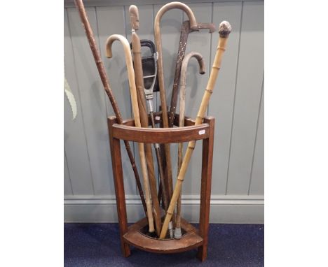 A QUANTITY OF WALKING STICKSincluding a shooting stick, in an oak corner stick stand