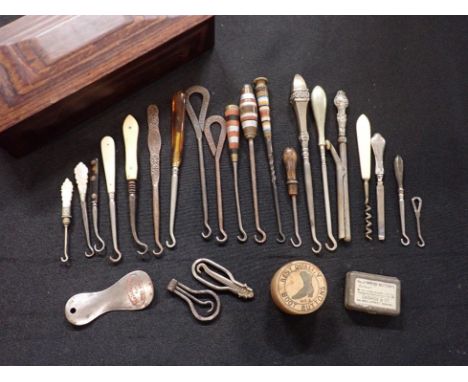 A COLLECTION OF BUTTON HOOKS AND OTHER ITEMSincluding some advertising and silver-handled examples, contained in a wooden box