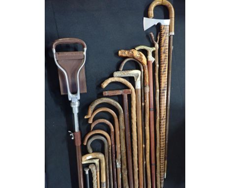 A COLLECTION OF WALKING STICKSincluding a thumb stick, a shooting stick, brass handled with fitted flask, etc