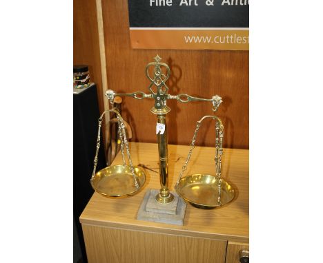 A BRASS SET OF SCALES ON A MARBLE BASE 