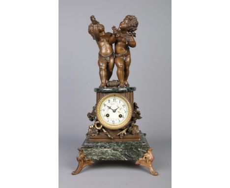 A French marble mantel clock surmounted with a pair of bronzed putti. The movement stamped for AD Mougin. Height 46cm.