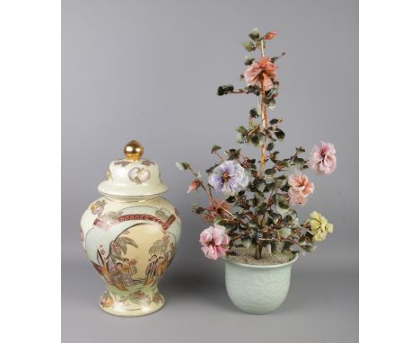 A large crystal plant with coloured flowers in celadon green planter along with an Oriental lidded vase decorated with figure