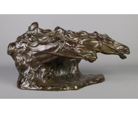 A bronze sculpture modelled as two horses heads. Signed R De Wandeleir. Height 26cm, Length 50cm.