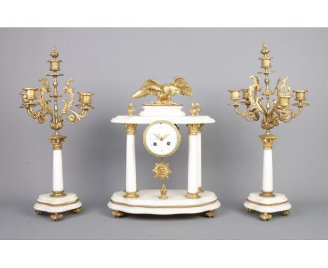 A French alabaster and gilt metal clock garniture. The clock with four column supports and surmounted with an eagle flanked b
