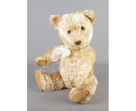 A 1950s Chiltern blonde jointed bear. Seated height 38cm.