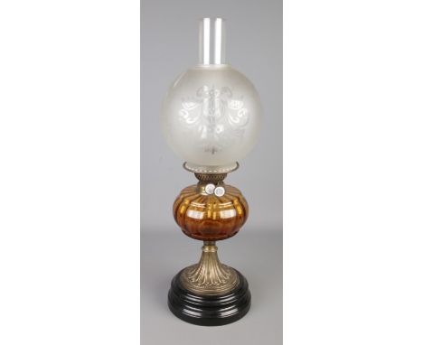 A brass and glass oil lamp featuring amber glass reservoir and circular etched shade. Approx. height 60cm.
