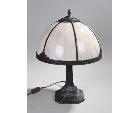 Art Nouveau style table lamp, with an arched shade above a leaf and criss cross stand