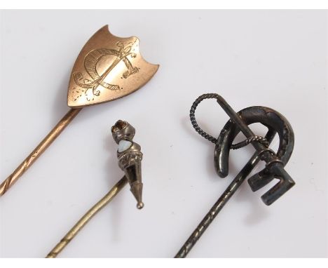 Three stick pins, to include a shield example, a horse shoe and crop example and a Scottish example, (3)