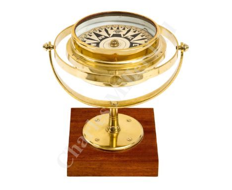 A DECORATIVE BRASS AND WOOD DESK COMPASS unsigned , the 5in. card with steel bars and jewelled pivot, contained within white 