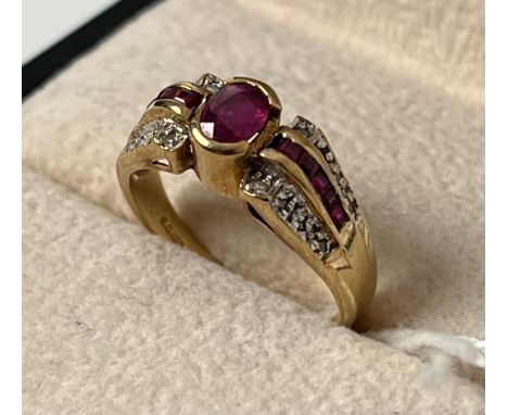 9ct yellow gold ring set with an oval cut ruby flanked by baguette cut rubies and round cut diamonds. [Ring size M] [2.75Gram
