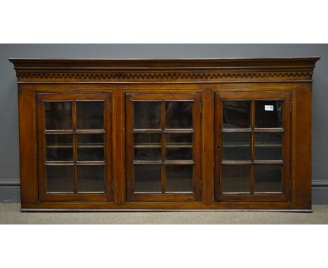 Early 20th century mahogany wall hanging cabinet, projecting cornice, three glazed doors, single shelf, W142cm, H71cm, D23cm 