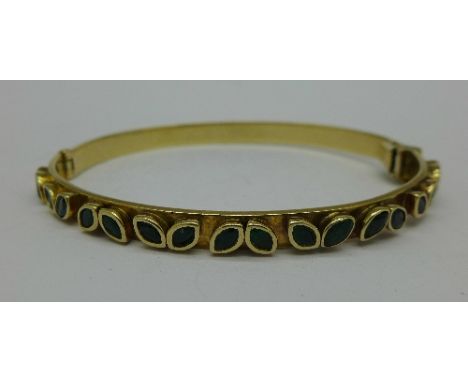 A 9ct gold and emerald bangle, 24.6g
