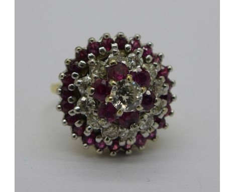 An 18ct gold, ruby and diamond cluster cocktail ring, c.1960's, approximate diamond weight 0.90 carat, 9.9g, N½, diameter 16m