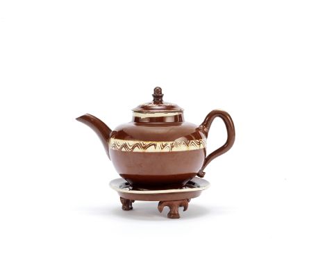 A rare Staffordshire glazed redware teapot, cover and stand, circa 1740-50Of compressed globular form, decorated with a broad