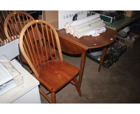 A drop leaf table raised on tapering supports with a set of three stick back chairs 