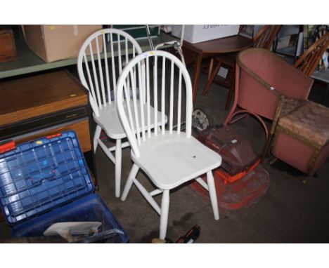 A pair of white painted stick back dining chairs