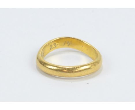 An 18ct yellow gold wedding band of unusual twisted form, inscribed to the interior of the band 'Joshua 23.14', size K 1/2, a