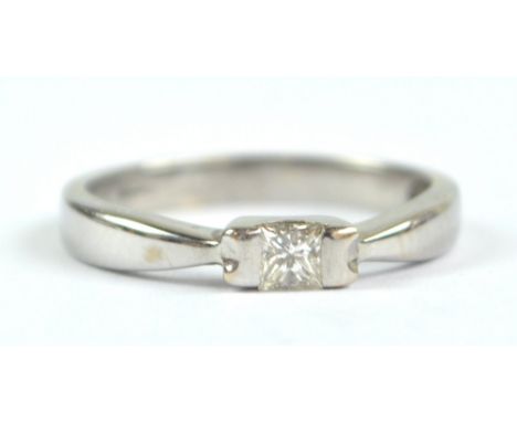 A white metal solitaire diamond ring, the princess cut stone measuring approx 0.2ct in tension setting, size K, with rubbed m