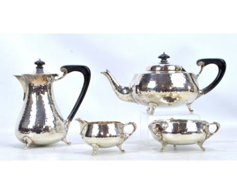 CHARLES EDWARDS; a George V hallmarked silver Arts and Crafts four piece tea service with beaten decoration, London 1923, len