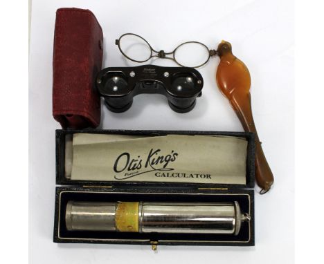 A cased Otis King's Patent calculator, model K, with manual, a pair of bakelite opera glasses in red leather pouch and a pair