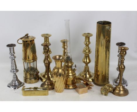 A mixed lot of brassware to include a miner's lamp, shell casing, candlesticks, etc.