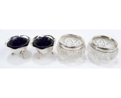 JOSEPH GLOSTER LTD; a pair of George V hallmarked silver shaped circular open salts on three supports with blue glass liners,