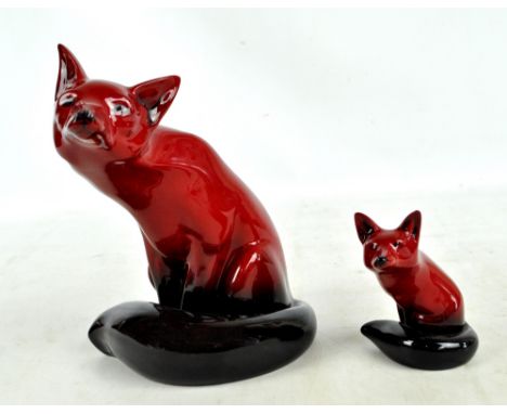 Two Royal Doulton flambé figures of foxes, the larger signed by Noke to base, height 23.5cm, the other unsigned, height 11cm 