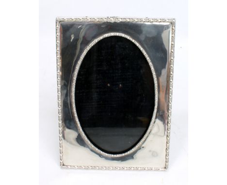 JAMES DEAKIN & SON; a George V hallmarked silver rectangular frame with bead and reel decoration, Sheffield 1917, the oval ap