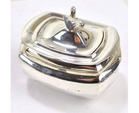 An Edward VII hallmarked silver tea caddy of shaped rectangular bellied form, with hinged lid and cast finial modelled as a l