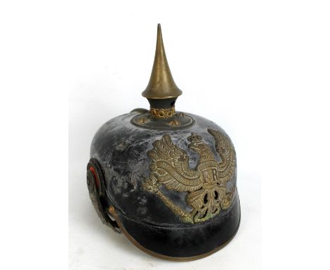 A WWI Prussian Pickelhaube with spike, plate and scale-type finish to chin strap, brown leather lining to interior base with 