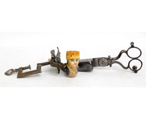 A Victorian brass clam decorated with a bird, a pair of candle snuffers and a ceramic figural pipe (3).