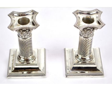 A pair of Victorian hallmarked silver wrythen twist Corinthian column candlesticks with bead decorated detachable sconces and