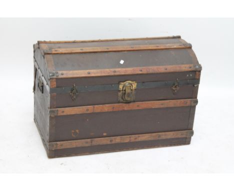A domed travelling trunk with twin handles to sides, width approx 84cm.