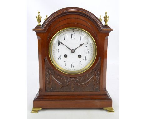 A mahogany cased mantel clock with brass finials, the circular dial set with Arabic numerals and indistinctly stamped 'Armstr