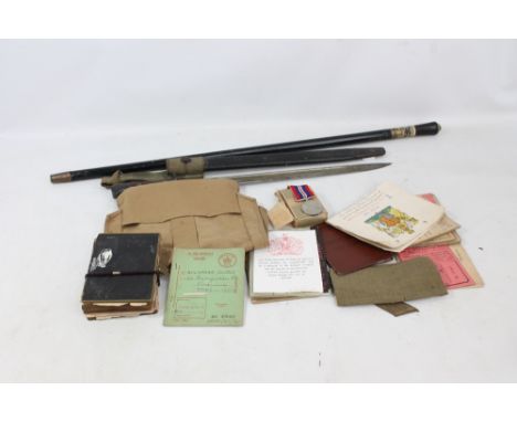 A small group of military effects including a 1939-1945 medal, chevrons, pay book, bible, etc, a Wilkinson WWI bayonet with b