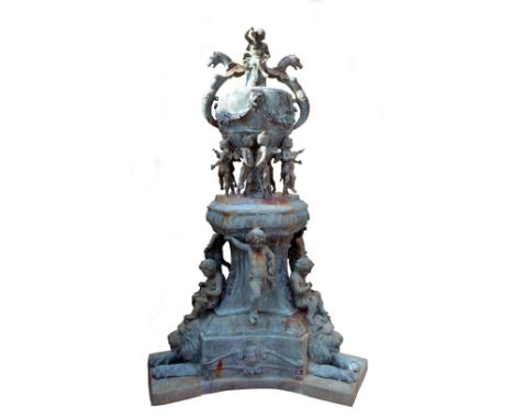 An elaborate cast metal fountain in the form of an urn with twin lion head spouts, surmounted by a seated putto flanked by a 