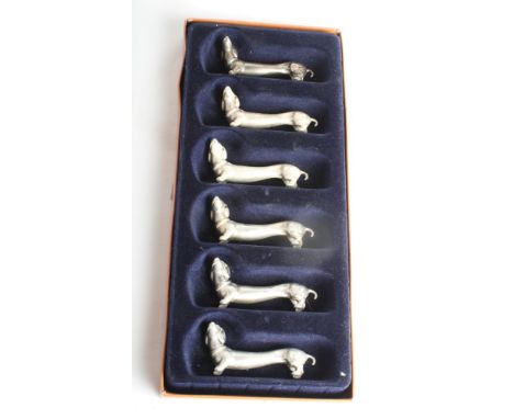 A boxed set of six white metal dachshund knife rests and a gilt metal cased pocket watch with decorative back and "pearl" set