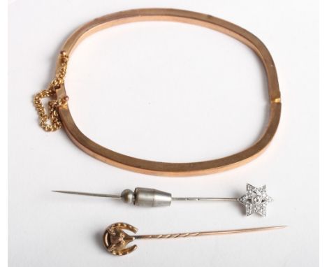 A white metal and diamond mounted star stickpin, a 15ct gold hunting related stickpin and a yellow metal hinged bangle stampe