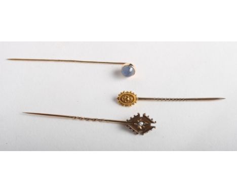 A gold stick pin set rose diamond and two other gold stick pins